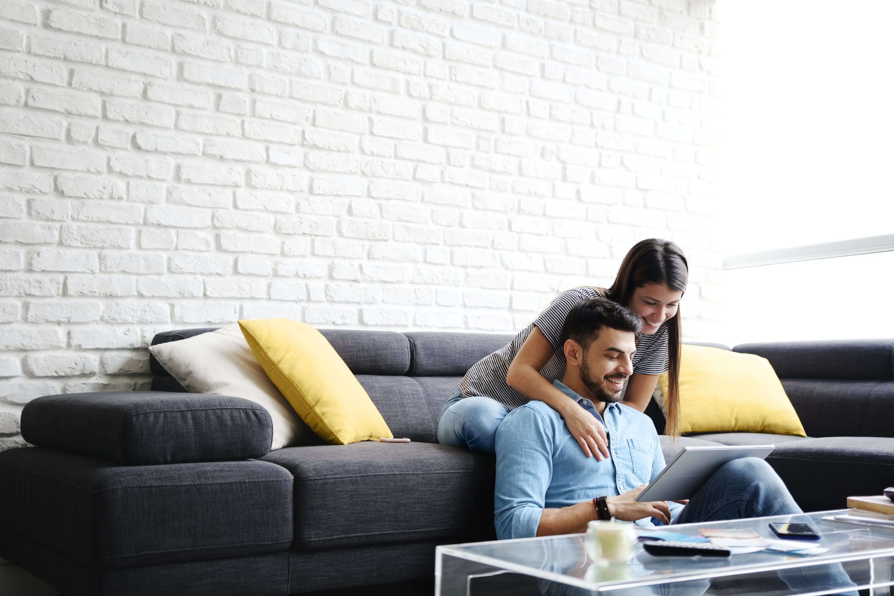 couple on couch looking at ipad